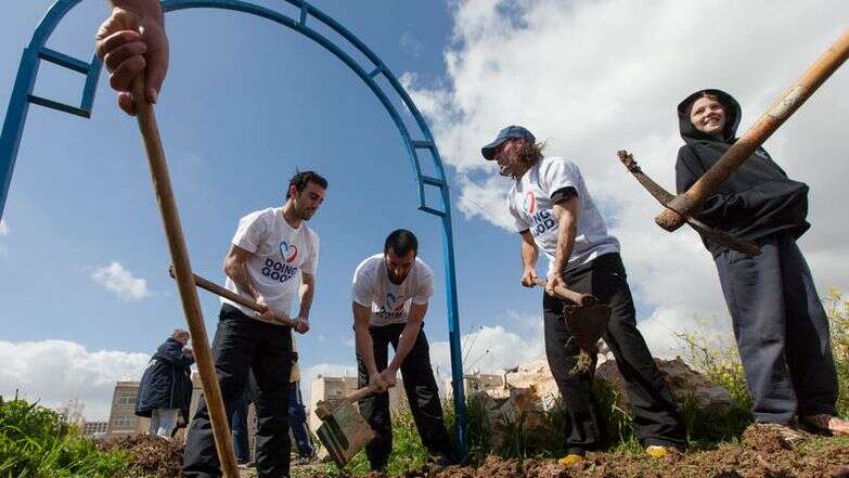 שחקני מועדון הכדורגל בית"ר ירושלים, זאור סדאייב (שני משמאל) ודריו פרננדז (שני מימין), מבצעים עבודות גינון ביום המעשים הטובים בשכונת ארמון הנציב בירושלים, ב-5 במרץ 2013 | פלאש 90