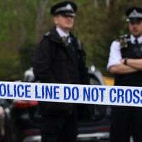 שוטרים עומדים בתפקיד בגדר סמוך לבית הכנסת  פינצ'לי, באזור צפון פינצ'לי בצפון לונדון, ב-15 באפריל 2026, לאחר מתקפה על בית הכנסת בשעות הבוקר המוקדמות | AFP