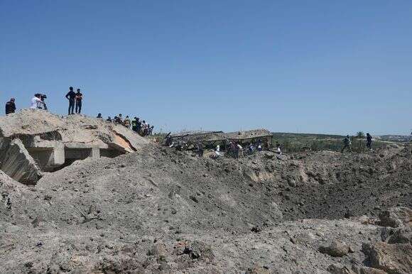 אנשים חוצים ברגל מכתש שנוצר מתקיפה אווירית ישראלית שהרסה את גשר קאסמיה ליד צור, לבנון | Mohammed Zaatari / AP