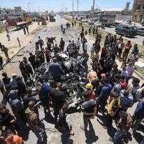 עזתים בוחנים רכב של פעילי חמאס שהותקף אתמול במחנה אלבוריג' | AFP