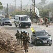 חיילי יוניפי"ל בדרום לבנון, על רקע רכבים עם דגלי חיזבאללה | AFP