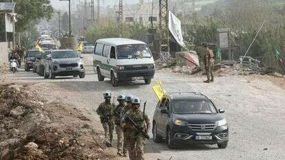 חיילי יוניפי"ל בדרום לבנון, על רקע רכבים עם דגלי חיזבאללה | AFP