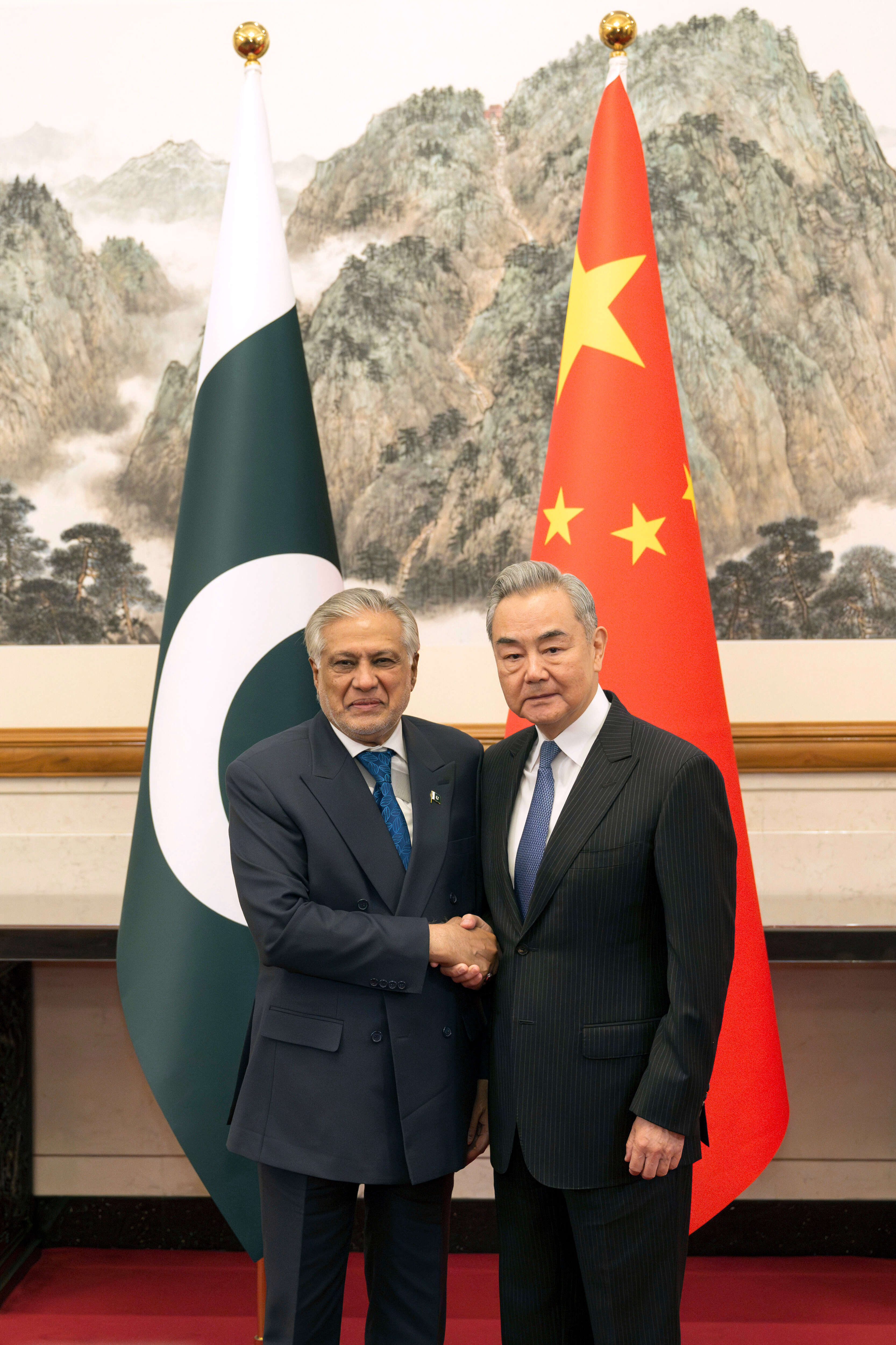 שר החוץ הסיני וואנג יי, מימין, לוחץ את ידו של סגן ראש ממשלת פקיסטן ושר החוץ מוחמד אסחאק דאר בבייג'ינג ב-31 במרץ 2026 | Cai Yang/Xinhua via AP