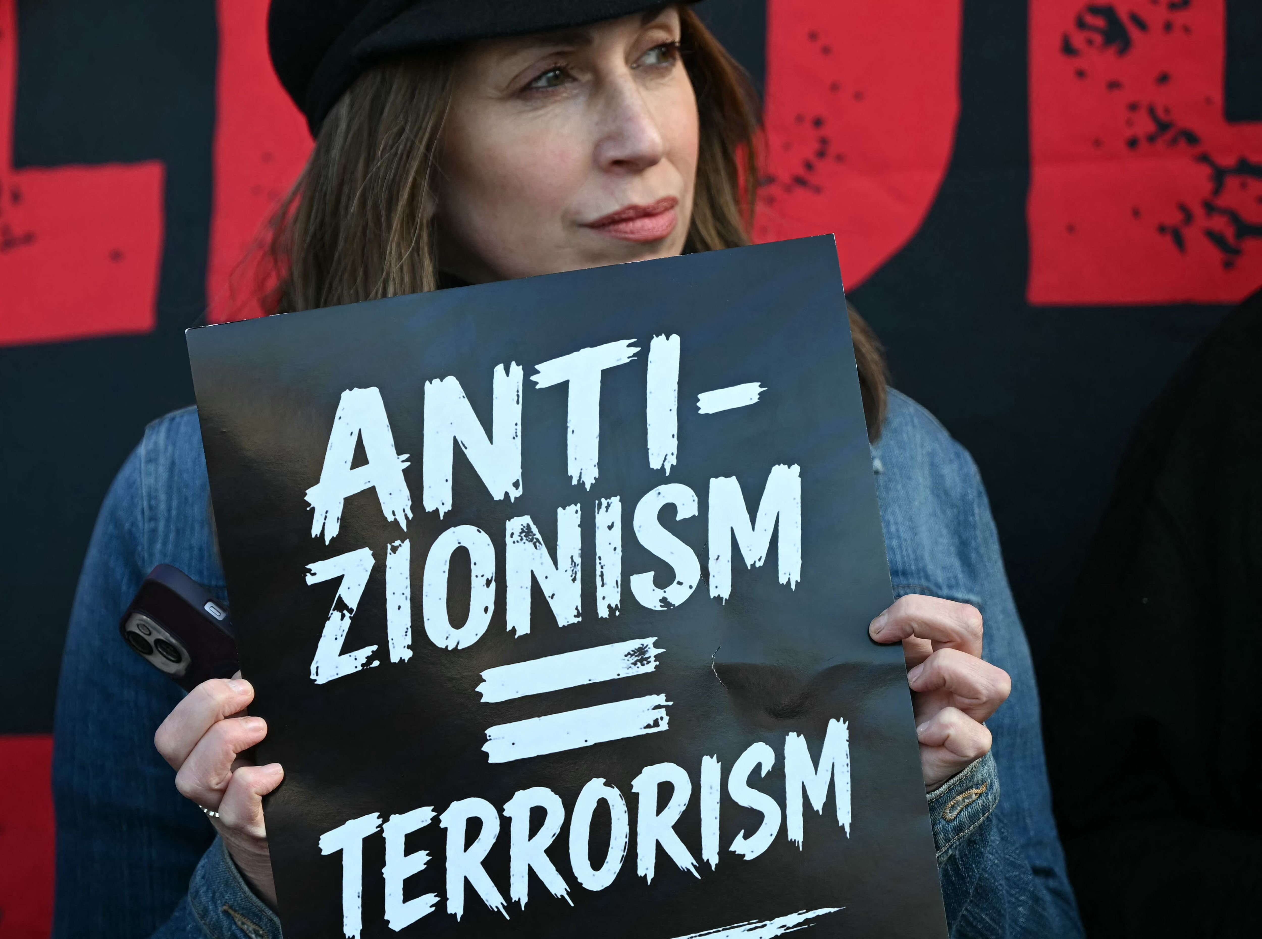 אישה אוחזת בשלט עליו נכתב "אנטי-ציונות = טרור" בהפגנה בצפון לונדון, לאחר הפיגוע שאירע שם. אפריל 2026 | AFP אישה אוחזת בשלט עליו נכתב "אנטי-ציונות = טרור" בהפגנה בצפון לונדון, לאחר הפיגוע שאירע שם. אפריל 2026 | AFP
