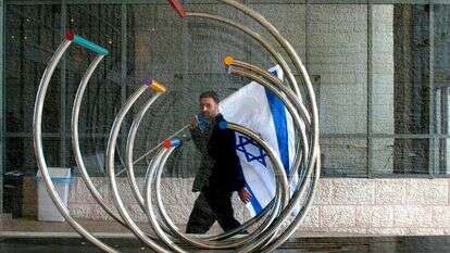 עובד ישראלי של יד שרה נושא דגל ישראל וחולף על פני פסל של הפסל הישראלי המפורסם יעקב אגם, בזמן שהם מתכוננים לקבל את פני ראש עיריית ניו יורק לביקור ב-1 בפברואר 2007 במכון יד שרה בירושלים | אוליבייה פיטוסי / Flash90 עובד ישראלי של יד שרה נושא דגל ישראל וחולף על פני פסל של הפסל הישראלי המפורסם יעקב אגם, בזמן שהם מתכוננים לקבל את פני ראש עיריית ניו יורק לביקור ב-1 בפברואר 2007 במכון יד שרה בירושלים | אוליבייה פיטוסי / Flash90