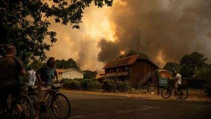 אחת משרפות הענק בצרפת, יולי 26 | (FILES) Residents on their bicycle look at smoke rising behind a residential area during a wildfire near Lege-Cap-Ferret, southwestern France on July 23, 2026. France has been battered by three heatwaves since May as part of increasingly common extreme weather episodes linked to climate change, causing thousands of excess deaths and fuelling wildfires. (Photo by JULIEN DE ROSA / AFP) אחת משרפות הענק בצרפת, יולי 26 | (FILES) Residents on their bicycle look at smoke rising behind a residential area during a wildfire near Lege-Cap-Ferret, southwestern France on July 23, 2026. France has been battered by three heatwaves since May as part of increasingly common extreme weather episodes linked to climate change, causing thousands of excess deaths and fuelling wildfires. (Photo by JULIEN DE ROSA / AFP)