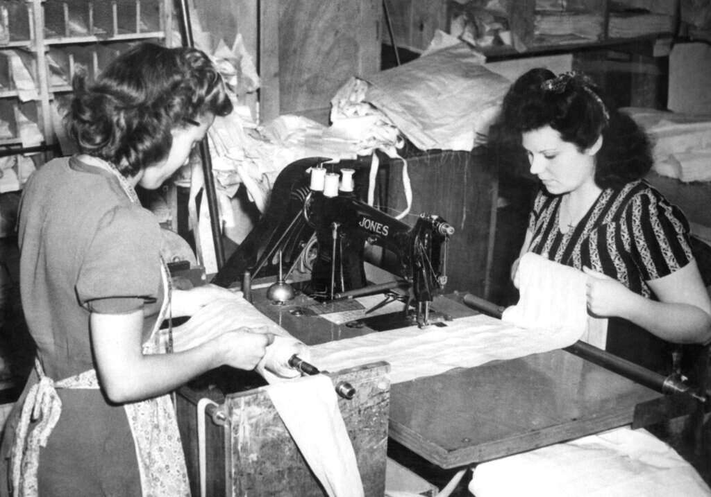 מיס אניד ריינולדס (משמאל) וגברת ג'סטין קוטיל כשהן מכינות אפודים, אנגליה (1943) | AP מיס אניד ריינולדס (משמאל) וגברת ג'סטין קוטיל כשהן מכינות אפודים, אנגליה (1943) | AP