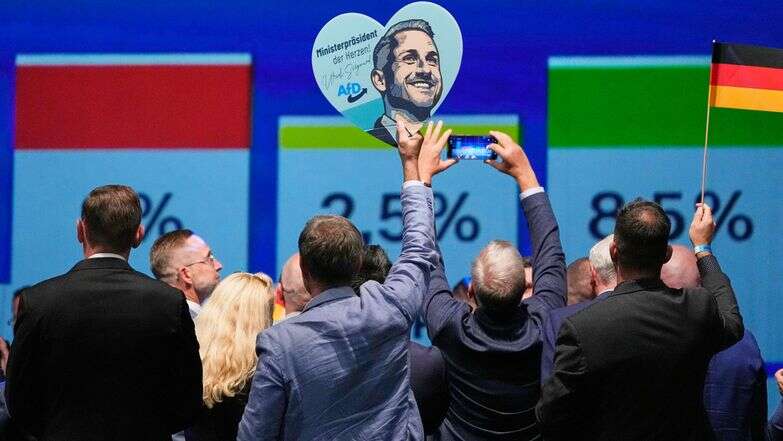 חברי מפלגה חוגגים עם שלט הנושא את תמונתו של אולריך זיגמונד, המועמד המוביל של מפלגת "אלטרנטיבה לגרמניה" | AP חברי מפלגה חוגגים עם שלט הנושא את תמונתו של אולריך זיגמונד, המועמד המוביל של מפלגת "אלטרנטיבה לגרמניה" | AP