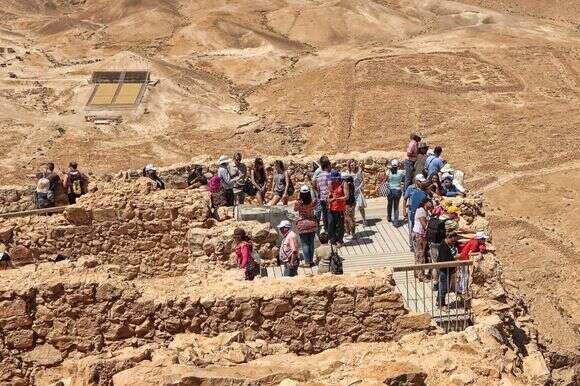 "אבא העביר שם הדרכות כאילו הוא עצמו היה בקבוצת הנצורים כשמצדה נפלה". תיירים צופים אל מחנה הליגיון הרומי למרגלות המצדה | שאטרסטוק