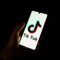 אפליקציית טיטוק בסמארטפון | (FILES) This photograph taken on April 19, 2024 shows a man holding a smartphone displaying the logo of Chinese social media platform TikTok in an office in Paris. A high-profile Japanese anime voice actor has taken TikTok to court over videos he says feature an artificial intelligence clone of his "lustrous" baritone, with a verdict due on September 30, 2026. (Photo by Antonin UTZ / AFP) אפליקציית טיטוק בסמארטפון | (FILES) This photograph taken on April 19, 2024 shows a man holding a smartphone displaying the logo of Chinese social media platform TikTok in an office in Paris. A high-profile Japanese anime voice actor has taken TikTok to court over videos he says feature an artificial intelligence clone of his "lustrous" baritone, with a verdict due on September 30, 2026. (Photo by Antonin UTZ / AFP)