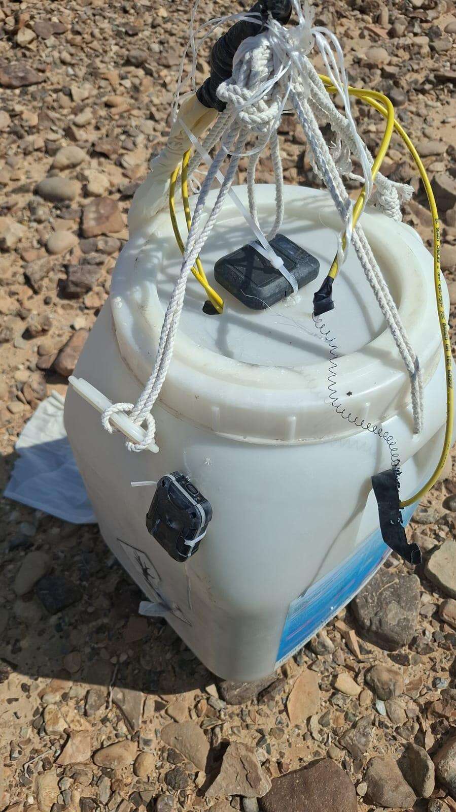 מכל פלסטיק ששימש להברחה באמצעות בלוני הליום, ולצידו חבלים ורכיבים אלקטרוניים שנועדו לאפשר את איתור המטען | תנועת רגבים מכל פלסטיק ששימש להברחה באמצעות בלוני הליום, ולצידו חבלים ורכיבים אלקטרוניים שנועדו לאפשר את איתור המטען | תנועת רגבים