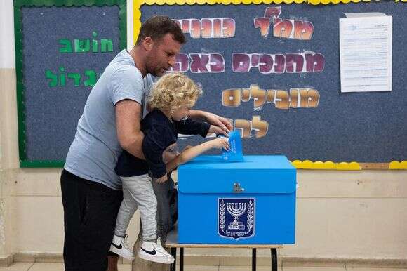 ילד משלשל את פתק אביו בקלפי | יונתן זינדל, פלאש 90 ילד משלשל את פתק אביו בקלפי | יונתן זינדל, פלאש 90