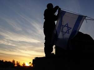 חייל צה''ל מניף דגל ישראל על טנק לפני כניסה לרצועת עזה. חייל צה''ל מניף דגל ישראל על טנק לפני כניסה לרצועת עזה.