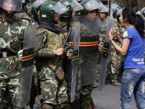 אישה אויגורית מפגינה מול כוחות הביטחון באורומצ'י. אישה אויגורית מפגינה מול כוחות הביטחון באורומצ'י.