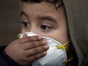 ילד לובש מסכה נגד שפעת החזירים. ילד לובש מסכה נגד שפעת החזירים.