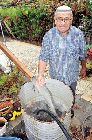 עזרא ממלא עוד חבית מים בחצר ביתו בבית שאן עזרא ממלא עוד חבית מים בחצר ביתו בבית שאן