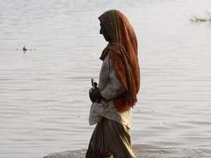 אישה חוצה את מי השיטפונות בדרך לביתה. אישה חוצה את מי השיטפונות בדרך לביתה.