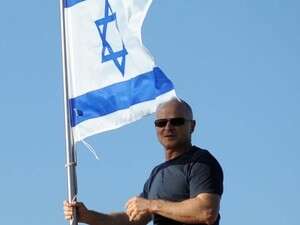 נועם שליט תולה את הדגל על גג הבית של המשפחה במצפה הילה נועם שליט תולה את הדגל על גג הבית של המשפחה במצפה הילה