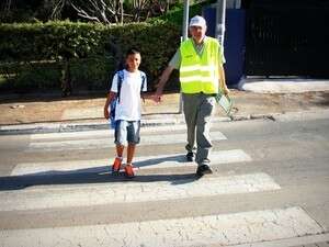 ילד חוצה את הכביש בעזרת מתנדב ילד חוצה את הכביש בעזרת מתנדב