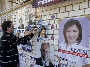 פעילים מדביקים מודעות של מועמדים בפריימריז בעבודה פעילים מדביקים מודעות של מועמדים בפריימריז בעבודה