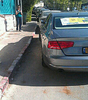 האוטו של משה ליאון ליד הקלפי חונה באדום לבן האוטו של משה ליאון ליד הקלפי חונה באדום לבן