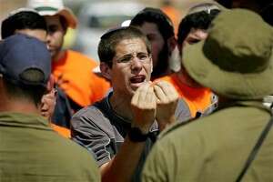 מתנגדי ההתנתקות מול החיילים באופקים. צילום: אי-פי מתנגדי ההתנתקות מול החיילים באופקים. צילום: אי-פי