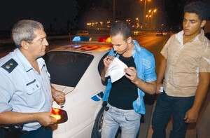 שוטר מבצע בדיקת אלכוהול לנהג צעיר. שוטר מבצע בדיקת אלכוהול לנהג צעיר.