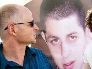 נועם שליט על רקע תמונת בנו, החייל החטוף גלעד. נועם שליט על רקע תמונת בנו, החייל החטוף גלעד.