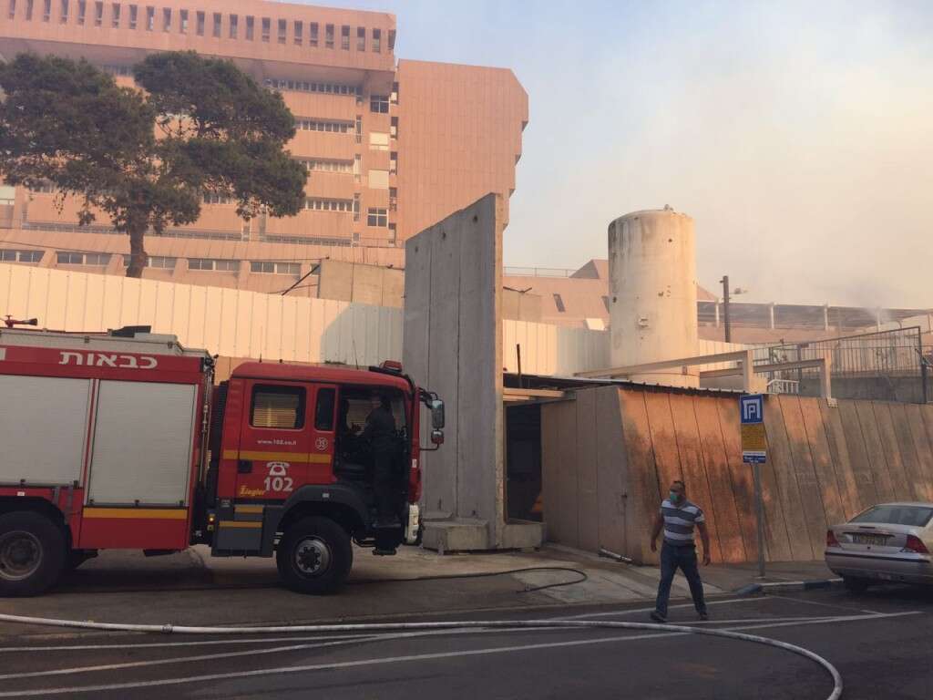 בצילום - ביה"ח כרמל מוקף באש, מגינים על מיכלי החמצן של ביה"ח קרדיט - צילום אלי דדון