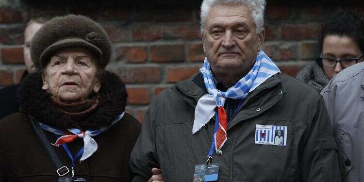 ניצולי שואה מחוץ למחהנ ההשמדה אושוויץ בירקנאו. צילום: AP צילום: AP