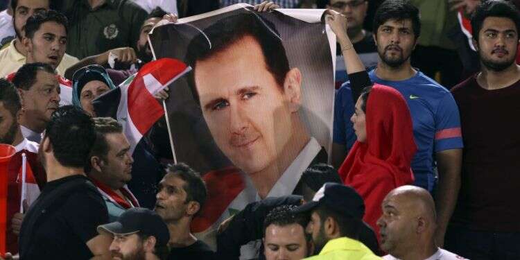 אוהדים סורים עם כרזה שנושאת את דמותו של אסד. צילום: AP צילום: AP