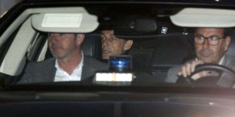 סרקוזי (במרכז) ביציאה מתחנת המשטרה. צילום: AP צילום: AP