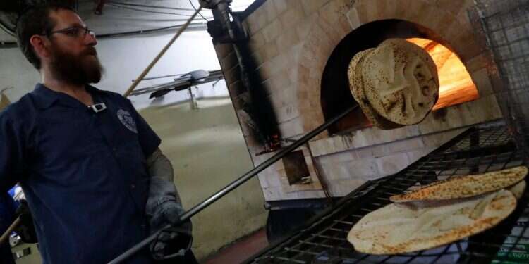 לכבוד ליל הסדר: הכנת מצות שמורות לפסח במאפייה בכפר חב צילום: AFP