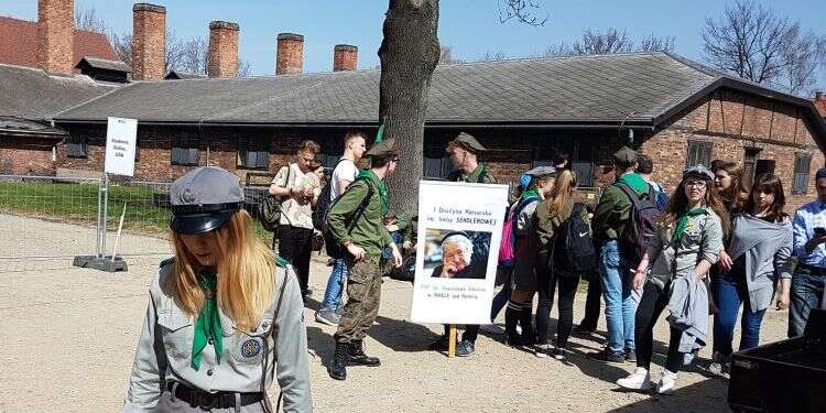 נערים מתנועת הצופים הפולנית מניפים כרזה עם תמונתה של אירנה סנדלר במחנה הריכוז אושוויץ. 2018. צילום: שמואל פאוסט צילום: שמואל פאוסט