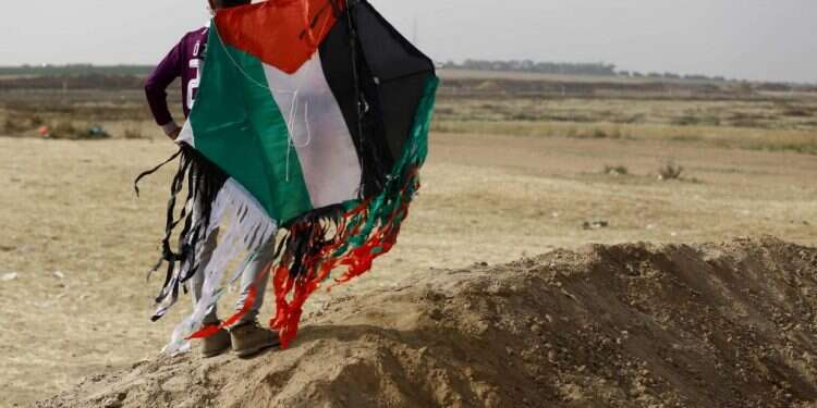 פלסטיני עם עפיפון תבערה ברצועת עזה. צילום: AFP פלסטיני עם עפיפון תבערה ברצועת עזה. צילום: AFP