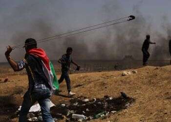 פעילים פלסטינים תוקפים את גדר ההפרדה. צילום: גטי אימג'ס