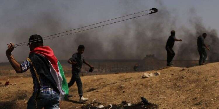 פעילים פלסטינים תוקפים את גדר ההפרדה. צילום: גטי אימג'ס פעילים פלסטינים תוקפים את גדר ההפרדה. צילום: גטי אימג'ס