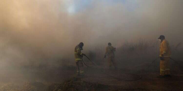 חייל מכבה שרפה בעוטף עזה. צילום: AFP    צילום: AFP