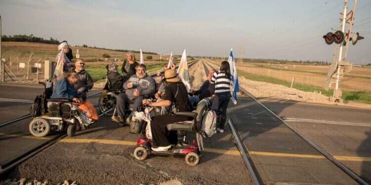 נכים מוחים על פסי הרכבת. צילום: קובי ריכטר- TPS צילום: קובי ריכטר- TPS