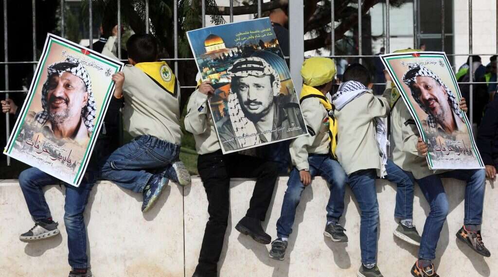 ילדים פלסטינים מניפים שלטים לזכרו של יאסר ערפאת. צילום: EPA צילום: EPA