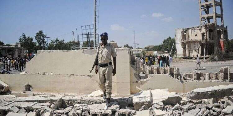 חייל סומלי עומד בזירת פיגוע התאבדות של אל-שבאב. צילום: AFP צילום: AFP