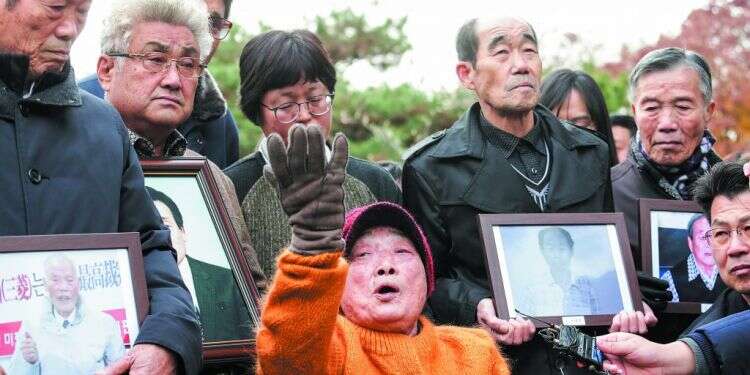 עובדת כפייה לשעבר במיצובישי מפגינה מול בית המשפט. צילום: AP צילום: AP