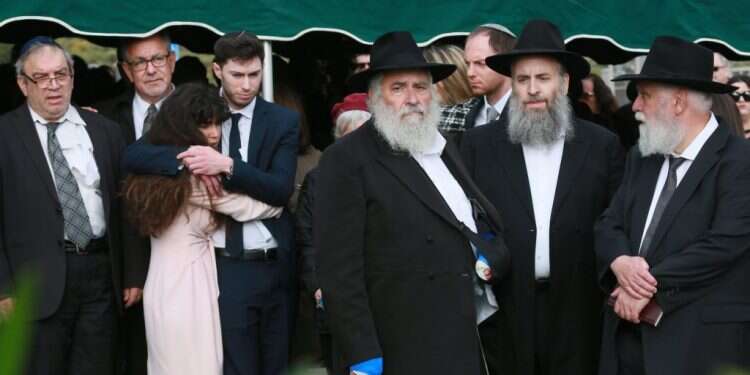 בני המשפחה בהלווייתה של לורי גילברט קיי, השבוע. במרכז: הרב ישראל גולדשטיין שנפצע בפיגוע. צילום: AFP צילום: AFP
