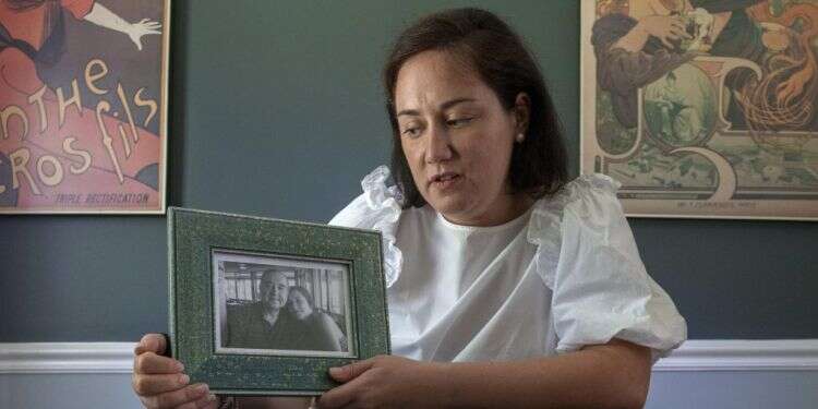 טטיאנה לאגוס עם תמונה של אביה. צילום: Doug Kapustin for The Washington Post צילום: Doug Kapustin for The Washington Post