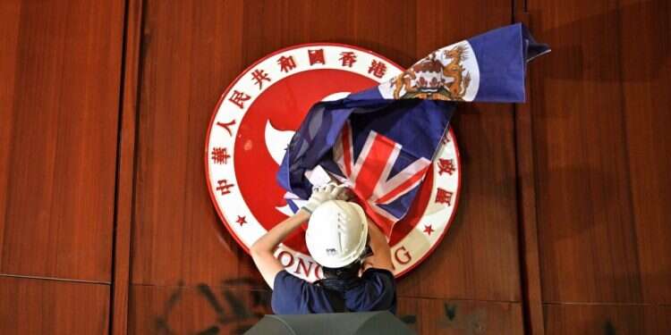 מפגין מניף את דגל הונג־קונג הקולוניאלית בפרלמנט, השבוע. צילום: AFP צילום: AFP