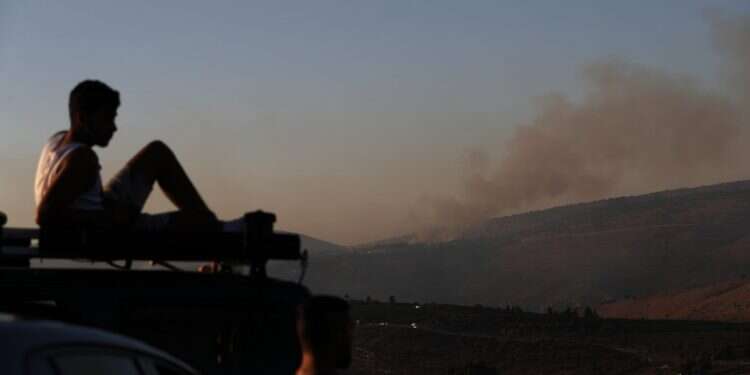 ישראלי צופה בשריפות סמוך לאביבים, אתמול. צילום: EPA צילום: EPA