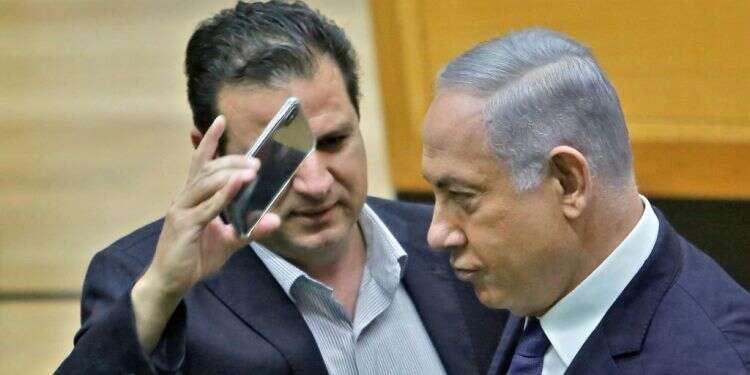 בנימין נתניהו ואיימן עודה בהצבעה על חוק המצלמות. צילום: AFP צילום: AFP