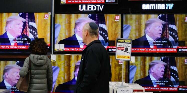 עוברי אורח במודיעין צופים בנאומו של הנשיא טראמפ. צילום: AFP הושלם המהפך: טראמפ הוכיח את מה שהימין טוען כבר יובל