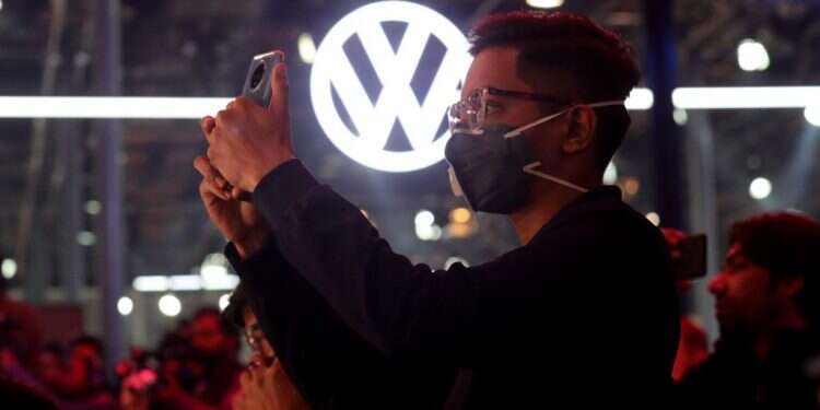 אדם עוטה מסכה בתצוגת רכבים בהודו. צילום: EPA משבר הקורונה: מותגים צריכים להוכיח את מחויבותם לעולם בריא