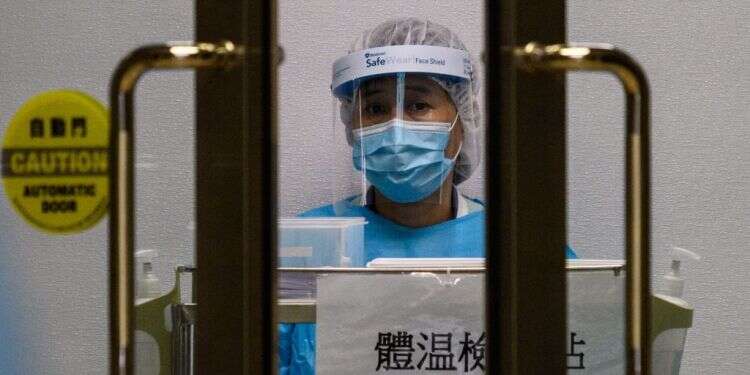 עובדת בבית חולים בהונג קונג לבושה בבגדי מגן לקראת טיפול בחולים. צילום: AFP כך תדעו שיש לכם קורונה